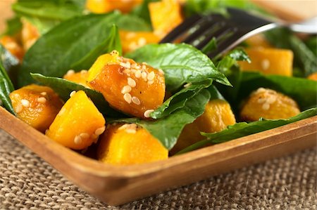 Baked pumpkin, spinach and sesame salad (Selective Focus, Focus on the pumpkin piece with many sesame seeds in the front) Stock Photo - Budget Royalty-Free & Subscription, Code: 400-05706810