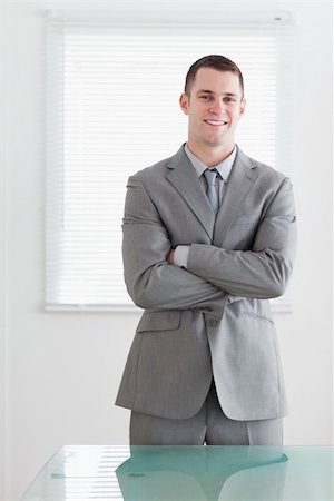 simsearch:400-06393704,k - Business man standing behind table with his arms folded and smiling Stockbilder - Microstock & Abonnement, Bildnummer: 400-05709453