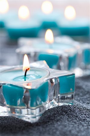 Close-up of blue candles in star shape holders on silver sand Stock Photo - Budget Royalty-Free & Subscription, Code: 400-05701286