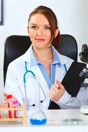 simsearch:400-04925813,k - Female medical doctor sitting in cabinet with clipboard Stock Photo - Budget Royalty-Free & Subscription, Code: 400-05701704