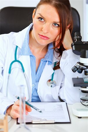 simsearch:400-07519214,k - Thoughtful doctor woman sitting at office table Stock Photo - Budget Royalty-Free & Subscription, Code: 400-05701706