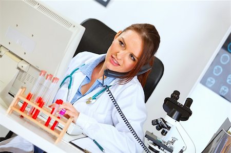 simsearch:400-04390415,k - Concerned female doctor talking on phone and looking in monitor Stock Photo - Budget Royalty-Free & Subscription, Code: 400-05701716
