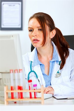 simsearch:400-04390415,k - Concerned medical doctor woman sitting at office table and working on computer Stock Photo - Budget Royalty-Free & Subscription, Code: 400-05701710