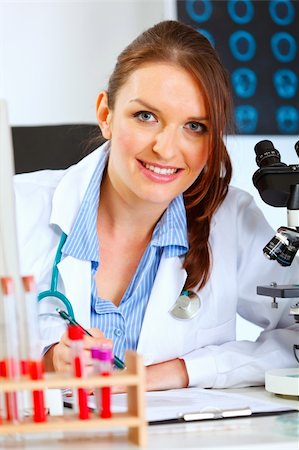 simsearch:400-04925813,k - Smiling female medical doctor working at her office Stock Photo - Budget Royalty-Free & Subscription, Code: 400-05701720