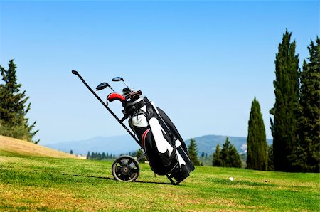 Golf bag with several clubs on a trolley on the fairway of a golf course Photographie de stock - Aubaine LD & Abonnement, Code: 400-05702838