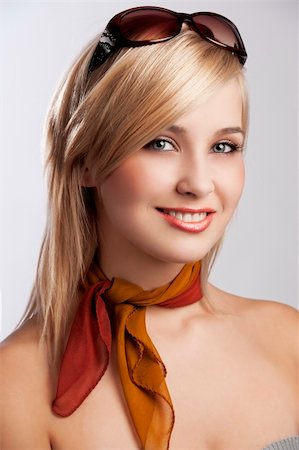 blond and beautiful young woman smiling in a fashion portrait wearing sunglasses and an autumn scarf Stock Photo - Budget Royalty-Free & Subscription, Code: 400-05703258