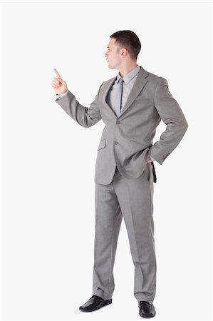 finger pointing up - Portrait of a businessman pointing at something against a white background Stock Photo - Budget Royalty-Free & Subscription, Code: 400-05714862