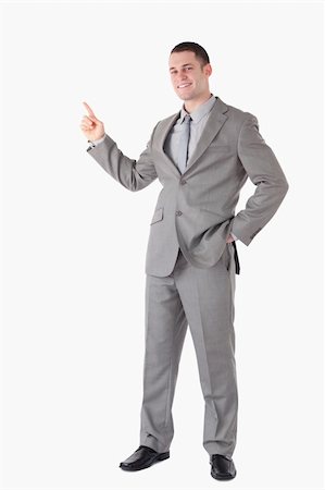 simsearch:400-05714996,k - Portrait of a smiling businessman pointing at something against a white background Foto de stock - Super Valor sin royalties y Suscripción, Código: 400-05714863