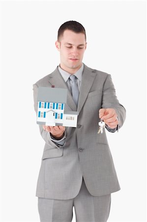 simsearch:400-07420953,k - Portrait of a businessman showing a miniature house and keys against a white background Stock Photo - Budget Royalty-Free & Subscription, Code: 400-05714894