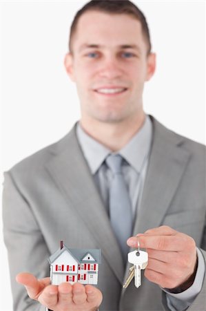 simsearch:625-02265924,k - Portrait of a young businessman showing a miniature house and a set of keys with the camera focus on the objects Photographie de stock - Aubaine LD & Abonnement, Code: 400-05714898