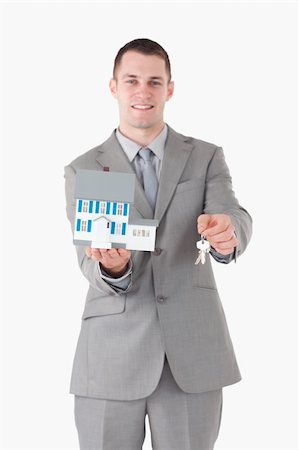 simsearch:400-07420953,k - Portrait of a businessman holding a miniature house and keys against a white background Stock Photo - Budget Royalty-Free & Subscription, Code: 400-05714893