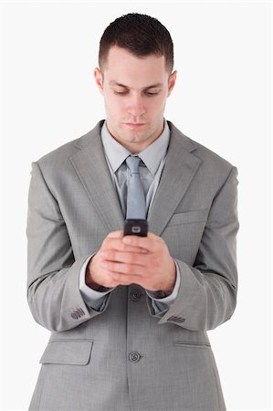 simsearch:400-05900688,k - Portrait of a businessman dialing on his cellphone against a white background Foto de stock - Super Valor sin royalties y Suscripción, Código: 400-05714912