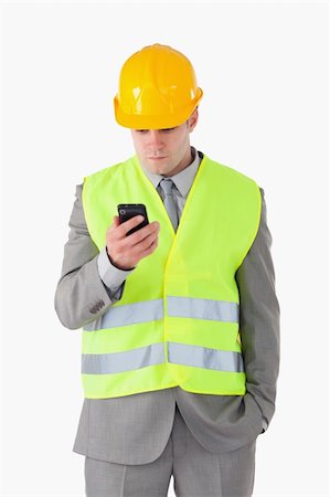 simsearch:400-05714957,k - Portrait of a young builder looking at his cellphone against a white background Stock Photo - Budget Royalty-Free & Subscription, Code: 400-05714948