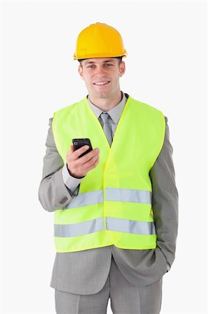 simsearch:400-05714957,k - Portrait of a young builder holding his cellphone against a white background Stock Photo - Budget Royalty-Free & Subscription, Code: 400-05714949