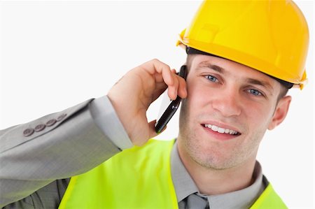 simsearch:400-05714957,k - Close up of a young builder making a phone call against a white background Stock Photo - Budget Royalty-Free & Subscription, Code: 400-05714955