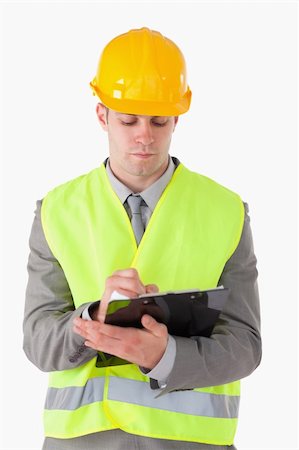 simsearch:400-05714957,k - Portrait of a young builder taking notes against a white background Stock Photo - Budget Royalty-Free & Subscription, Code: 400-05714956