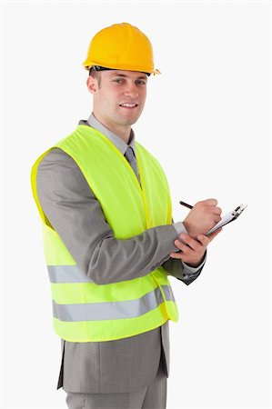 Portrait of a smiling builder holding a clipboard against a white background Stock Photo - Budget Royalty-Free & Subscription, Code: 400-05714958