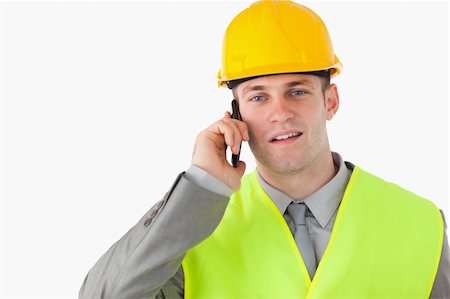 simsearch:400-05714957,k - Builder using his cellphone against a white background Stock Photo - Budget Royalty-Free & Subscription, Code: 400-05714952