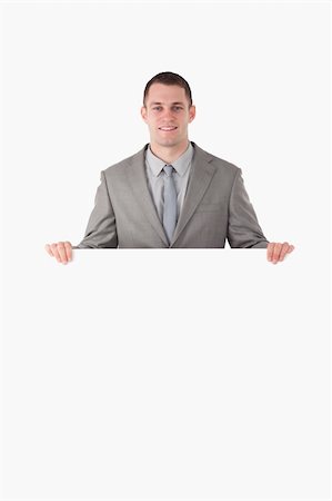 Portrait of a businessman behind a blank panel against a white background Stock Photo - Budget Royalty-Free & Subscription, Code: 400-05714978