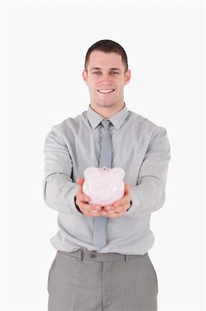 simsearch:400-05715051,k - Portrait of a businessman holding a piggy bank against a white background Fotografie stock - Microstock e Abbonamento, Codice: 400-05715036