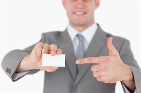 simsearch:400-05718318,k - Businessman pointing at a blank business card against a white background Foto de stock - Super Valor sin royalties y Suscripción, Código: 400-05715108