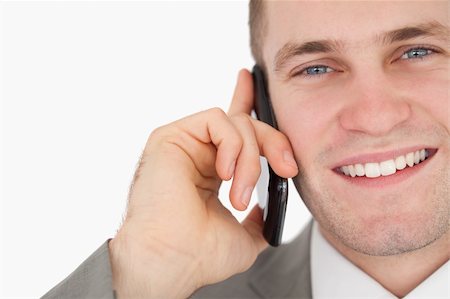 simsearch:400-05718346,k - Close up of a happy businessman making a phone call against a white background Foto de stock - Super Valor sin royalties y Suscripción, Código: 400-05715204