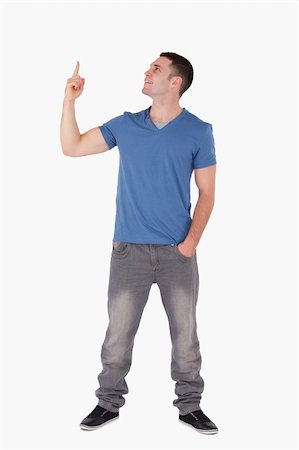 finger pointing up - Portrait of a young man pointing at something against a white background Stock Photo - Budget Royalty-Free & Subscription, Code: 400-05715218