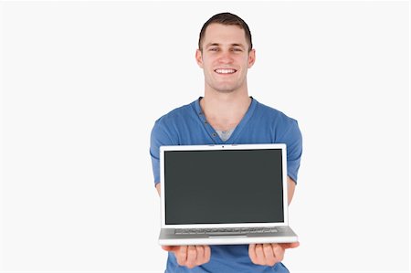 facing - Man showing a laptop against a white background Stock Photo - Budget Royalty-Free & Subscription, Code: 400-05715299