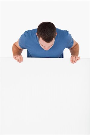 simsearch:400-05718227,k - Portrait of a man looking at a blank panel against a white background Stock Photo - Budget Royalty-Free & Subscription, Code: 400-05715311