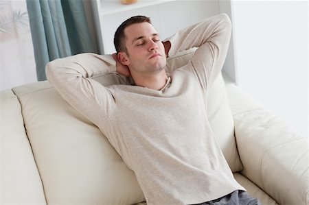 Man resting on a sofa in his living room Stock Photo - Budget Royalty-Free & Subscription, Code: 400-05715521