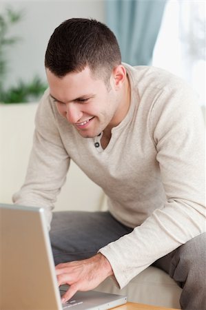 simsearch:400-05715585,k - Portrait of a smiling man using a notebook in his living room Foto de stock - Super Valor sin royalties y Suscripción, Código: 400-05715567