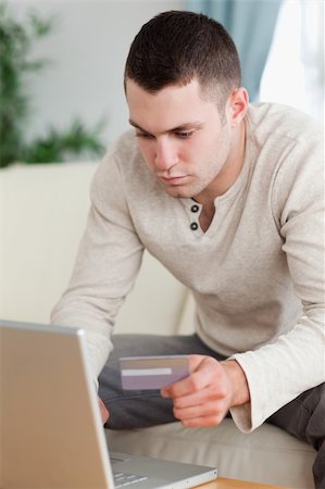 face card - Portrait of a man using a notebook to book a flight in his living room Stock Photo - Budget Royalty-Free & Subscription, Code: 400-05715568