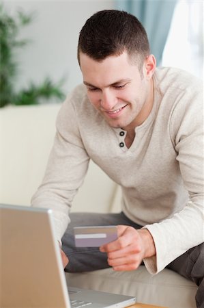 face card - Portrait of a man using a laptop to book a flight in his living room Stock Photo - Budget Royalty-Free & Subscription, Code: 400-05715569