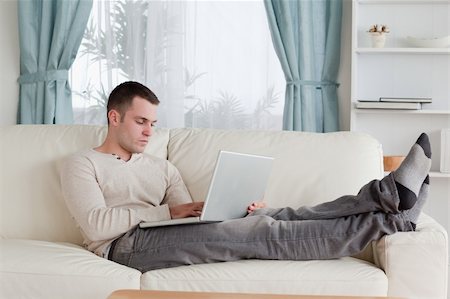 simsearch:400-05715585,k - Man relaxing with a laptop in his living room Foto de stock - Super Valor sin royalties y Suscripción, Código: 400-05715584