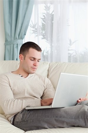 simsearch:400-05715661,k - Portrait of a man relaxing with a laptop in his living room Photographie de stock - Aubaine LD & Abonnement, Code: 400-05715586