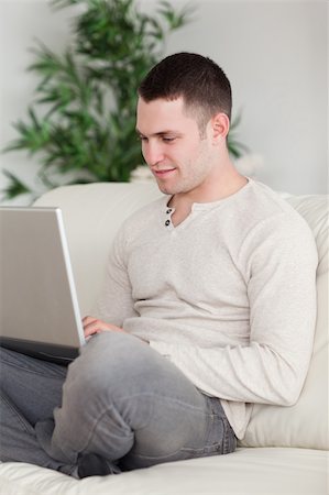 simsearch:400-05715661,k - Portrait of a young man relaxing with a notebook in his living room Photographie de stock - Aubaine LD & Abonnement, Code: 400-05715594