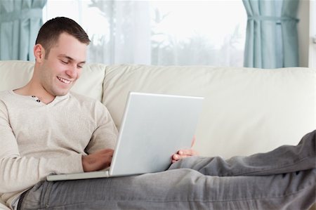 simsearch:400-05715528,k - Man relaxing with a notebook in his living room Stock Photo - Budget Royalty-Free & Subscription, Code: 400-05715590