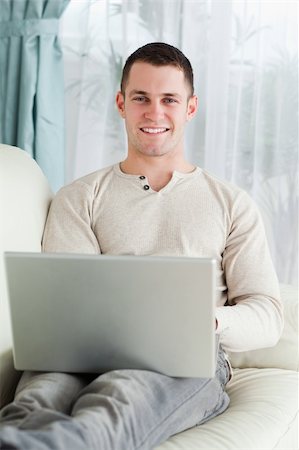 simsearch:400-05715661,k - Portrait of a young man working with his notebook in his living room Photographie de stock - Aubaine LD & Abonnement, Code: 400-05715617