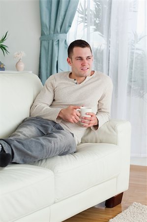 Man holding a cup of coffee in his living room Stock Photo - Budget Royalty-Free & Subscription, Code: 400-05715628