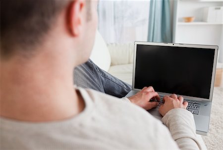 simsearch:400-05715661,k - Man lying on his couch while using a laptop in his living room Photographie de stock - Aubaine LD & Abonnement, Code: 400-05715650