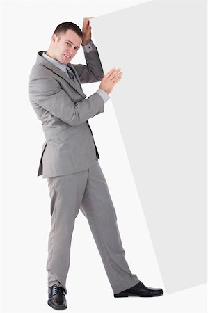 Portrait of young businessman pushing a blank panel against a white background Stock Photo - Budget Royalty-Free & Subscription, Code: 400-05715683