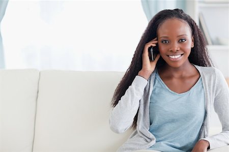 simsearch:400-05716936,k - Smiling young woman with cellphone on the sofa Stock Photo - Budget Royalty-Free & Subscription, Code: 400-05716408