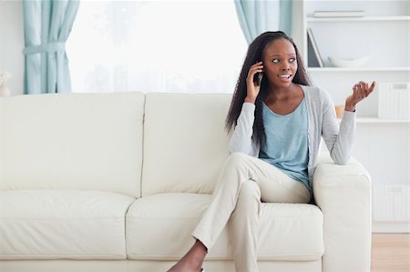 simsearch:400-05716936,k - Young woman talking on the phone while sitting on the sofa Stock Photo - Budget Royalty-Free & Subscription, Code: 400-05716402
