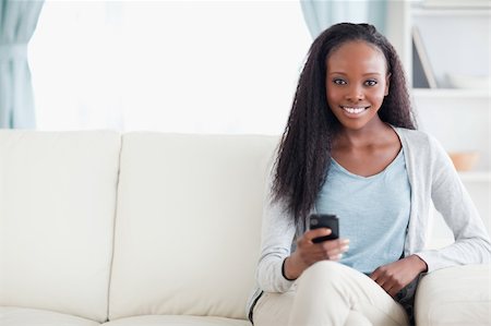 simsearch:400-05716936,k - Smiling woman typing a text message on the sofa Stock Photo - Budget Royalty-Free & Subscription, Code: 400-05716415