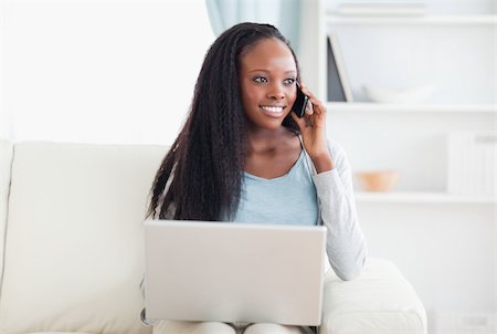 simsearch:400-05716936,k - Smiling woman with smartphone and laptop on the sofa Stock Photo - Budget Royalty-Free & Subscription, Code: 400-05716431