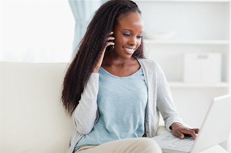 simsearch:400-05716936,k - Smiling woman on sofa with smartphone and laptop Stock Photo - Budget Royalty-Free & Subscription, Code: 400-05716444