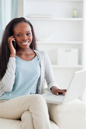 simsearch:400-05716936,k - Smiling woman with mobile phone and laptop on sofa Stock Photo - Budget Royalty-Free & Subscription, Code: 400-05716441