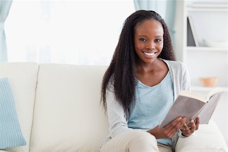 simsearch:400-05716909,k - Smiling woman reading a book on sofa Stock Photo - Budget Royalty-Free & Subscription, Code: 400-05716908