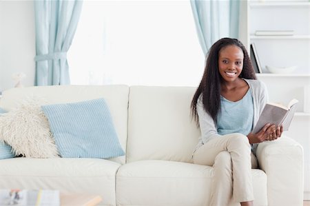 simsearch:400-05716909,k - Smiling woman on couch reading a book Stock Photo - Budget Royalty-Free & Subscription, Code: 400-05716915