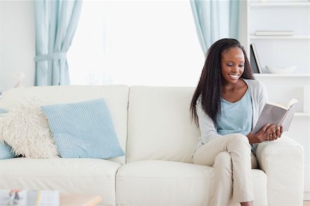 simsearch:400-05716909,k - Smiling woman reading a book in living room Stock Photo - Budget Royalty-Free & Subscription, Code: 400-05716916